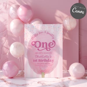 Op de afbeelding: Een roze verjaardagsuitnodiging met een suikerspinontwerp en de tekst "One". De uitnodiging bevat details voor Charlotte's 1e verjaardag, omringd door roze ballonnen. De achtergrond is zachtroze.