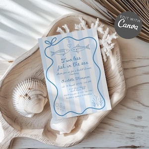 Op de afbeelding: Een uitnodiging voor een bruidsdouche met een blauw-witte gestreepte achtergrond, met twee vissen en de tekst "Two less fish in the sea". De uitnodiging ligt op een houten dienblad met schelpen en koraal.