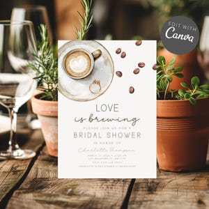 Op de afbeelding: Uitnodiging voor een bruidsdouche met een aquarel koffiekopje, ring en koffiebonen. De tekst luidt "Love is brewing" en bevat evenementdetails. Het ontwerp staat tegen een neutrale achtergrond met potplanten en een houten tafel.