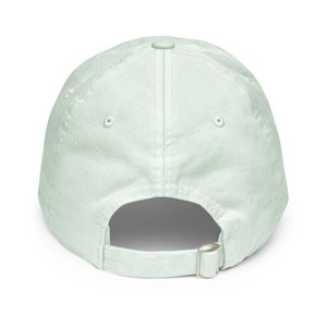 May include: A light green baseball cap with a buckle closure on the back.