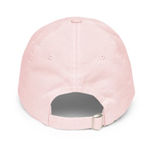May include: A plain pink baseball cap with an adjustable strap in the back.
