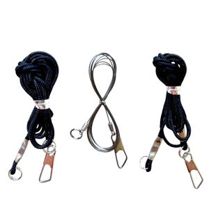 May include: Three black cords with silver clasps. Two cords are made of rope and one is made of metal.