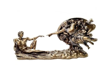 May include: A bronze sculpture depicting the famous "Creation of Adam" scene by Michelangelo. The sculpture features two figures, one reaching out to the other, with a swirling cloud of figures behind them.