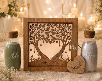 May include: A wooden wedding unity sand ceremony set. The set includes a wooden frame with a tree design, two sand bottles, and a wooden heart. The frame has the names "Alissa & Parker" and the date 08.08.2028 engraved.