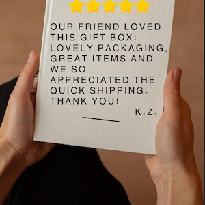 May include: A white rectangular card featuring the text Client Review above five yellow stars. The text reads: OUR FRIEND LOVED THIS GIFT BOX! LOVELY PACKAGING, GREAT ITEMS AND WE SO APPRECIATED THE QUICK SHIPPING. THANK YOU! K.Z.