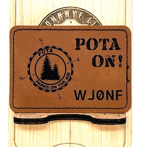 May include: A brown leather patch with a compass design and the text "POTA Parks on the Air" and "POTA ON! WJONF".