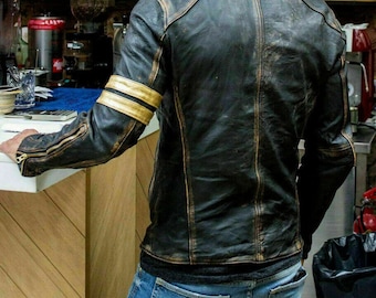 May include: A black leather jacket with distressed detailing and gold accents on the sleeves. The jacket has a zipper closure and a stand-up collar.