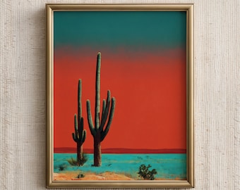 May include: A framed art print featuring a desert landscape with two tall saguaro cacti against a vibrant red and teal gradient sky. The cacti are green, and the ground is a mix of tan and turquoise. The frame is gold.