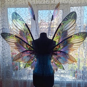 Since the wings are made of plastic, the pattern is clearly visible in the sunlight, the leaves and flowers seem three-dimensional