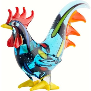 May include: A colorful glass rooster figurine with a blue body, red comb and wattle, and a yellow and green tail.