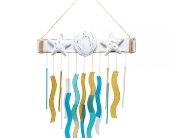 May include: White wooden wind chime with seashells and starfish hanging from it. The chime has blue and yellow glass pieces hanging from it.