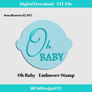 May include: A light blue round embosser stamp with the text "Oh Baby" in turquoise blue lettering. The stamp is 6 cm (2.36 inches) in diameter.