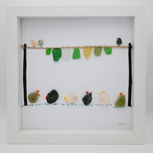 sea glass art, framed sea glass wall art, colorful pebble chickens sit underneath a laundry line with sea glass clothing with pebble birds.