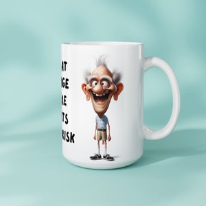 Mockup image of an 11oz or 15oz mug with a sublimation design featuring a funny old man and the text I am at the age where shorts are a risk The mug is displayed against a light blue background showing its physical appearance