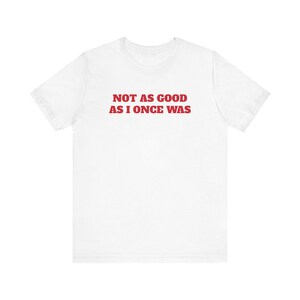 May include: White t-shirt with red text that reads "NOT AS GOOD AS I ONCE WAS".