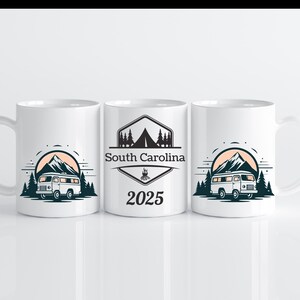Pode incluir: Caneca de cerâmica branca com um design que apresenta uma cordilheira montanhosa, uma autocaravana e pinheiros. O texto "South Carolina 2025" está impresso na caneca.
