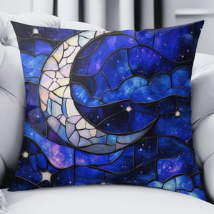 Könnte beinhalten: Quadratisches Kissen mit einem Buntglasdesign mit einem Halbmond und einem Sternenhimmel. Das Kissen hat einen dunkelblauen Hintergrund mit weißen und gelben Akzenten in Mond und Sternen.
