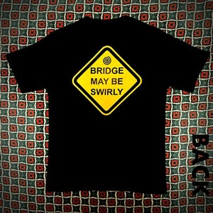 May include: Black t-shirt with a yellow diamond-shaped graphic. The graphic reads "BRIDGE MAY BE SWIRLY" in black text. The shirt has a simple design, suitable for casual wear.