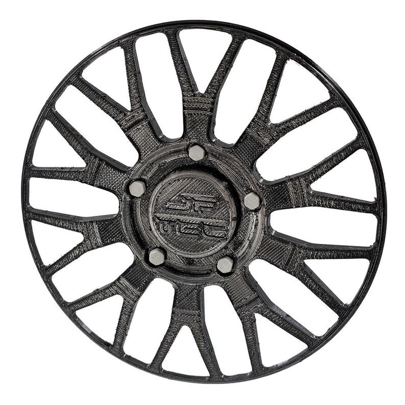 May include: A black car wheel with a complex, open spoke design. The wheel features a central hub with the letters "SC" and a series of bolts around the center. The wheel's design includes multiple triangular and curved elements.
