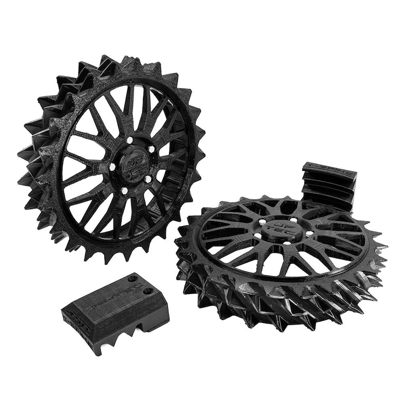 May include: Black 3D-printed mechanical components, including two gear-like wheels with intricate spoke designs and a rectangular piece. The wheels have a spiked outer edge. The components are likely for a machine or model.