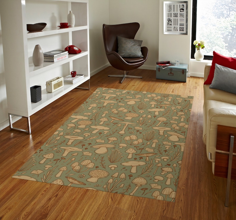 May include: A green and brown area rug with a mushroom pattern. The rug is in a living room with a white bookshelf, a brown leather egg chair, and a white couch.