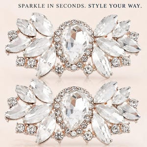 May include: Two crystal rhinestone detachable accessories featuring a central pear-shaped stone surrounded by marquise and round crystals. The text reads: CRYSTAL RHINESTONE Detachable Accessory, SPARKLE IN SECONDS. STYLE YOUR WAY., SECURE BOTTOM CLIP, Instant Elegance, PERFECT FOR, Dress Up Shoes, Clip onto Handbags, Attach to Belts, Pin on Lapel, Add to Gifts, Brilliant Crystals, Secure & Durable, Easy On Easy Off, Elegant Design, ONE CLIP. ENDLESS POSSIBILITIES.