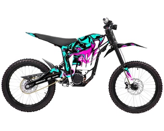 May include: An electric dirt bike with a black frame and wheels. The bike features a black seat and is decorated with a vibrant design of teal, pink, and black abstract shapes. The tires have a knobby tread for off-road use.