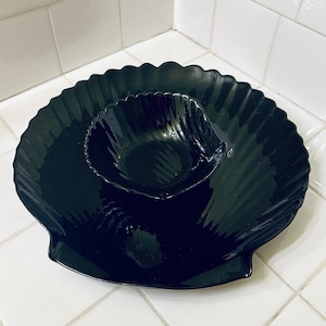 May include: A set of three ceramic mugs with a speckled, matte finish. Each mug features a different color: light blue, cream, and gray. The mugs have a simple, modern design with a rounded shape and a comfortable handle.