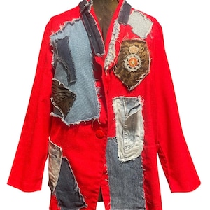May include: A bright red blazer featuring various denim patches with frayed edges sewn onto the front. The jacket includes a prominent crest-style patch on the upper left side, featuring a crown and star emblem, along with multiple blue denim panels.