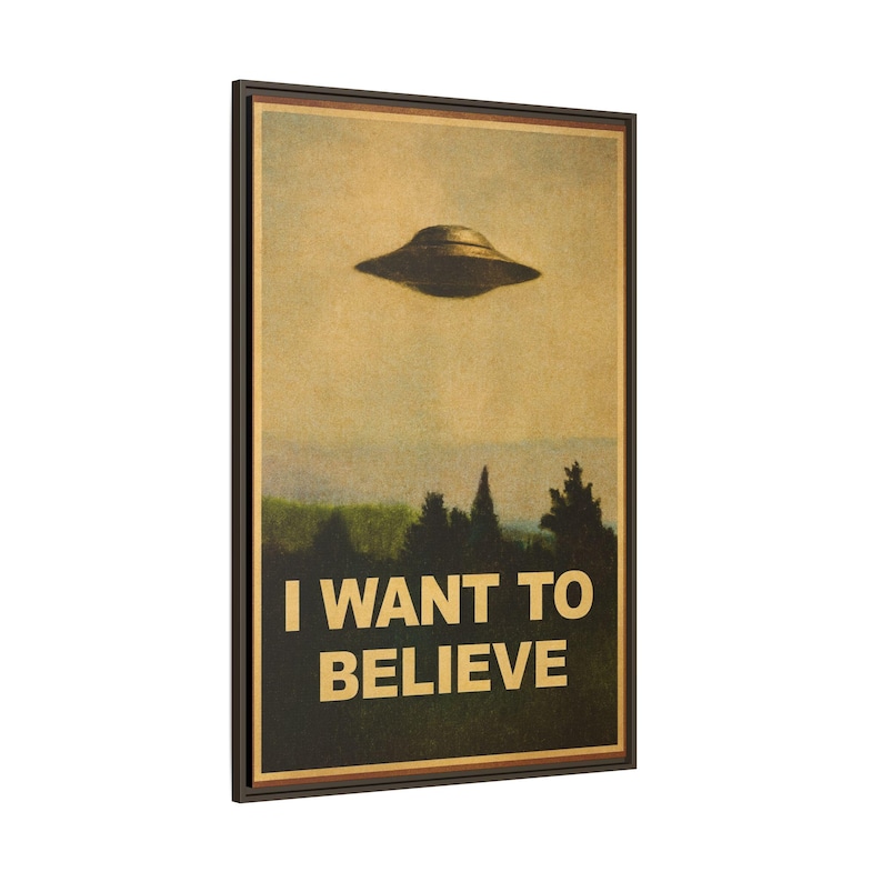 May include: Framed poster featuring a vintage-style image of a UFO hovering above a forest. The text "I WANT TO BELIEVE" is printed in bold, white letters at the bottom. The poster has a brown border.