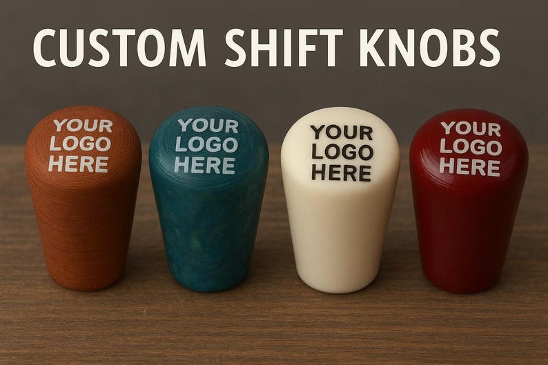 Może przedstawiać: Cztery niestandardowe gałki zmiany bieg&oacute;w, każda z napisem "YOUR LOGO HERE" w białym tekście. Gałki są w odcieniach brązu, turkusu, kremu i czerwieni. U g&oacute;ry znajduje się napis "CUSTOM SHIFT KNOBS".