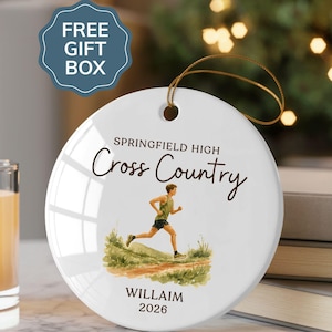 May include: A round white ceramic ornament featuring a gold hanging string. The text reads Springfield High Cross Country, Willaim, and 2026. A watercolor-style illustration shows a runner in green athletic gear on a dirt path with grass.