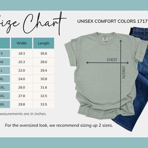 Puede incluir: Tabla de tallas para camisetas unisex Comfort Colors. Las medidas est&aacute;n en pulgadas. La tabla incluye ancho y largo para las tallas S a 4XL. Tambi&eacute;n se muestra una camiseta verde salvia y unos vaqueros azules. El texto "UNISEX COMFORT COLORS 1717" es visible.