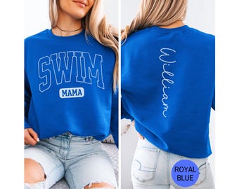 May include: Royal blue sweatshirt with the text "SWIM MAMA" in white block letters on the front. The back of the sweatshirt has the name "William" in white script. The sweatshirt is a solid royal blue color.