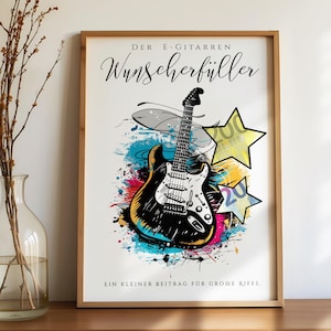 Op de afbeelding: Een ingelijste print met een zwart-witte illustratie van een elektrische gitaar met kleurrijke verfspatten. De print bevat de tekst "DER E-GITARREN WUNSCHERFÜLLER" en "EIN KLEINER BEITRAG FÜR GROSSE RIFFS."