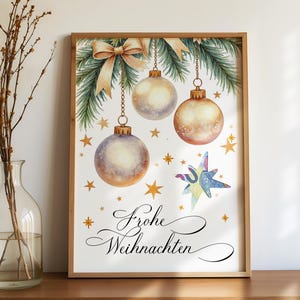 Könnte beinhalten: Ein gerahmter Aquarelldruck mit Weihnachtskugeln, Tannenzweigen und einer Schleife. Die Kugeln sind gold- und silberfarben, mit goldenen Sternen und einem bunten Stern. Der Text "Frohe Weihnachten" ist in eleganter Schrift geschrieben.