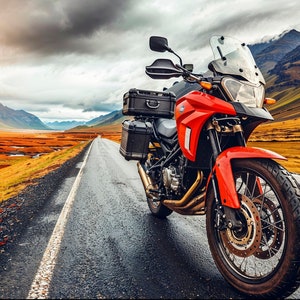 May include: A red motorcycle with black luggage is parked on a paved road in a mountainous landscape. The road is lined with a white stripe and the background features a valley with a lake and hills.
