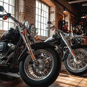 May include: Two black motorcycles parked in a garage with wooden floors. The motorcycles have chrome accents and large front wheels.