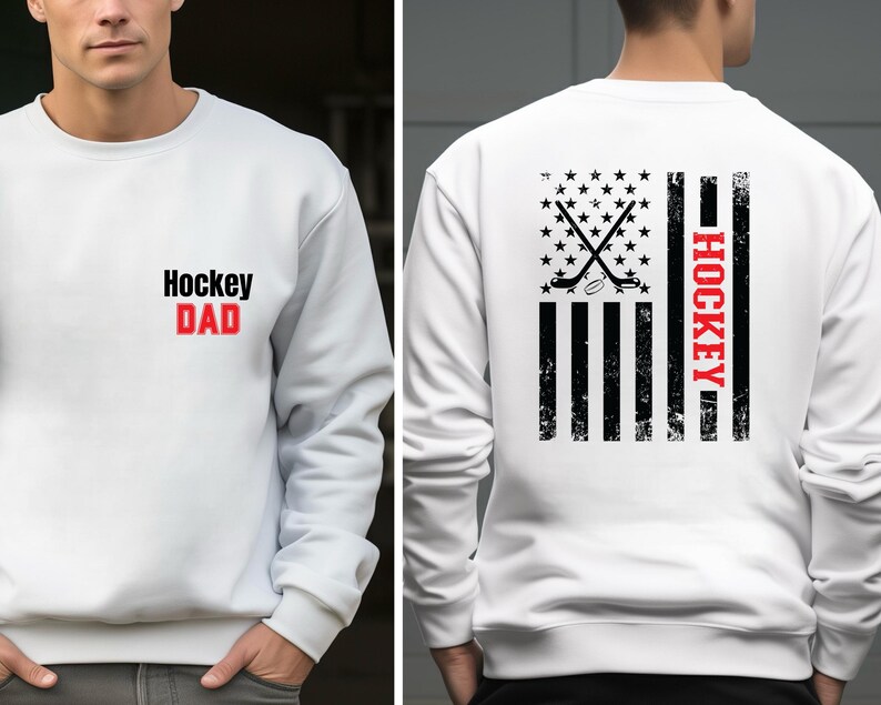 May include: White sweatshirt with a black and red graphic of a hockey stick and puck on a distressed American flag design. The text "HOCKEY" is written vertically on the right side of the flag. The front of the sweatshirt has the text "Hockey DAD" in black and red.