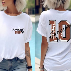 May include: White t-shirt with the text "Football Mom" and a heart on the front. The back of the shirt has a brown and white football design with the number "10" and the name "Jackson" written in cursive.