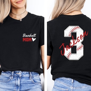May include: Black t-shirt with the text "Baseball Mom" and a red heart on the front. The back of the shirt has a white baseball number 3 with red stitching and the name "Jackson" written in red cursive.