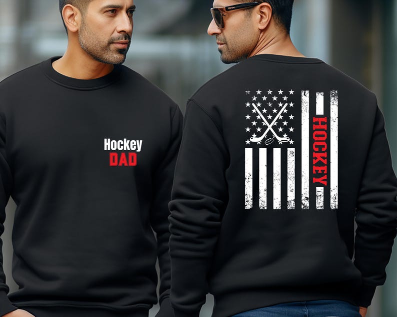 May include: Two black sweatshirts with a white American flag design. One sweatshirt has the text "Hockey Dad" on the front. The other sweatshirt has the text "Hockey" on the side of the flag.
