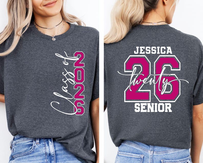 May include: Charcoal gray t-shirt with the text "Class of 2025" in white script and magenta block letters. The back of the shirt features the name "Jessica", the number "26", the word "twenty" in script, and the word "SENIOR" in white.