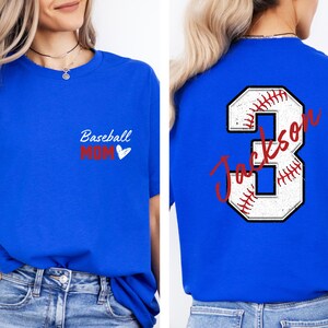 May include: Two royal blue t-shirts. One has the text "Baseball Mom" with a red heart. The other has a white baseball with red stitching and the number 3 with the text "Jackson" in red.