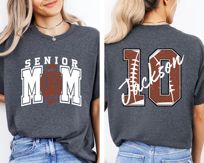 May include: A dark heather gray t-shirt featuring a front graphic with the text SENIOR MOM and a brown football. The back graphic displays the number 10 with a football texture and the name Jackson written in white cursive script across the number.