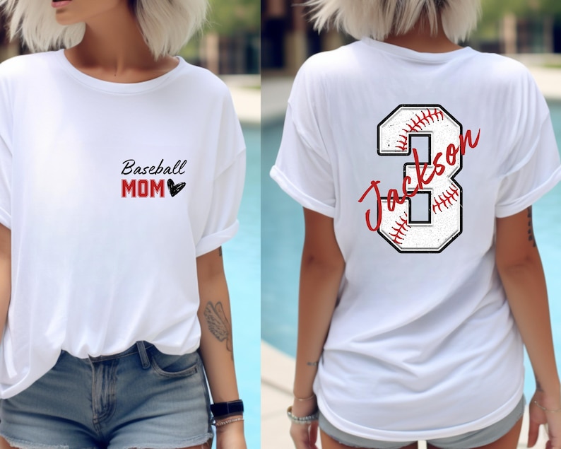 May include: White t-shirt with the text "Baseball Mom" and a heart on the front. The back of the shirt has a white baseball with a red stitching design and the number 3 with the name "Jackson" written on it.