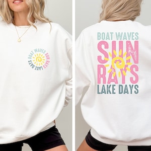 May include: White sweatshirt with a sun graphic and the text "Boat Waves Sun Rays Lake Days" on the front and back.