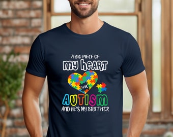 May include: A navy blue t-shirt with a white graphic that says "A big piece of my heart has autism and he's my brother". The graphic features a heart made of puzzle pieces in various colors.