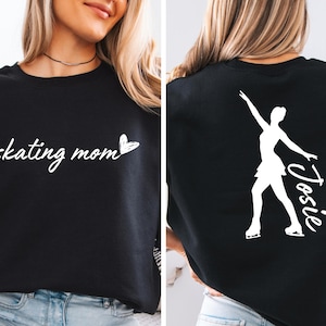 May include: Black sweatshirt with the text "skating mom" and a heart on the front. The back of the sweatshirt has a white silhouette of a figure skater with the name "Josie" written next to it.