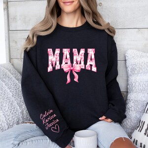 May include: Black sweatshirt with the word "MAMA" in pink and white letters with a pink bow. The sweatshirt has the names "Calvin, Karissa, Jessica" written on the sleeve.